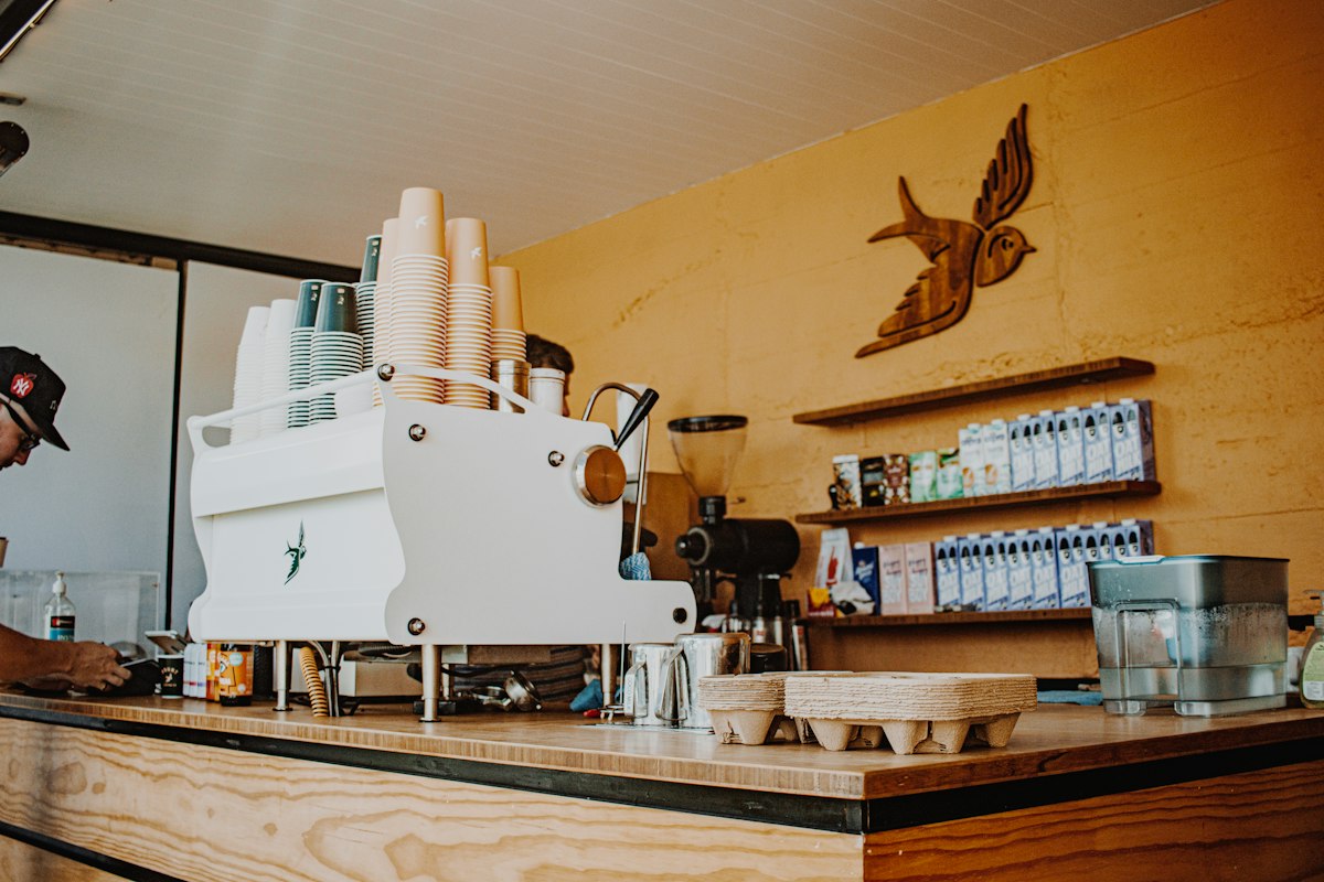 An espresso machine and coffee supplies on a café counter